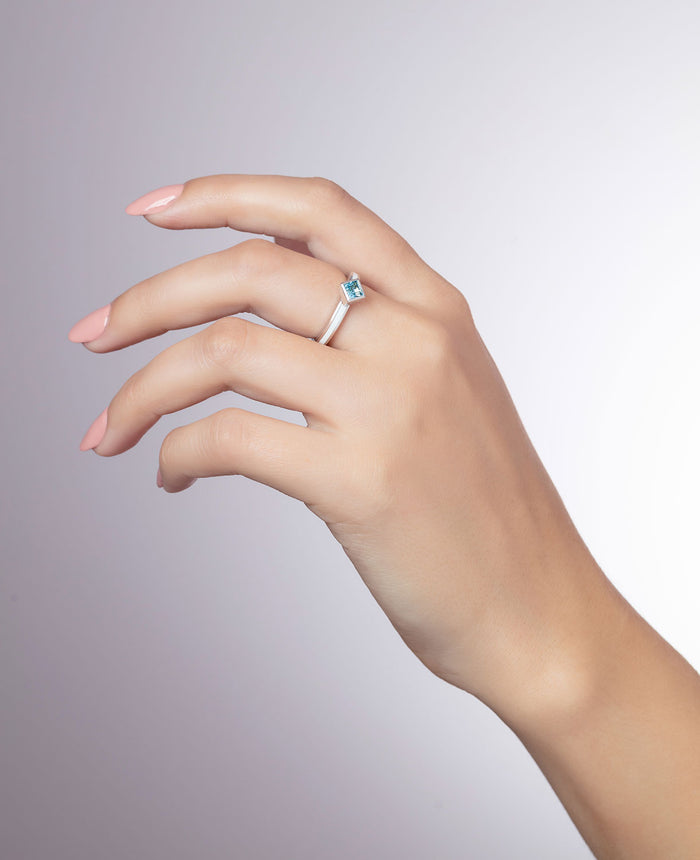 'Better together' sterling silver stacking ring with a square Ostro Blue Topaz being worn by model