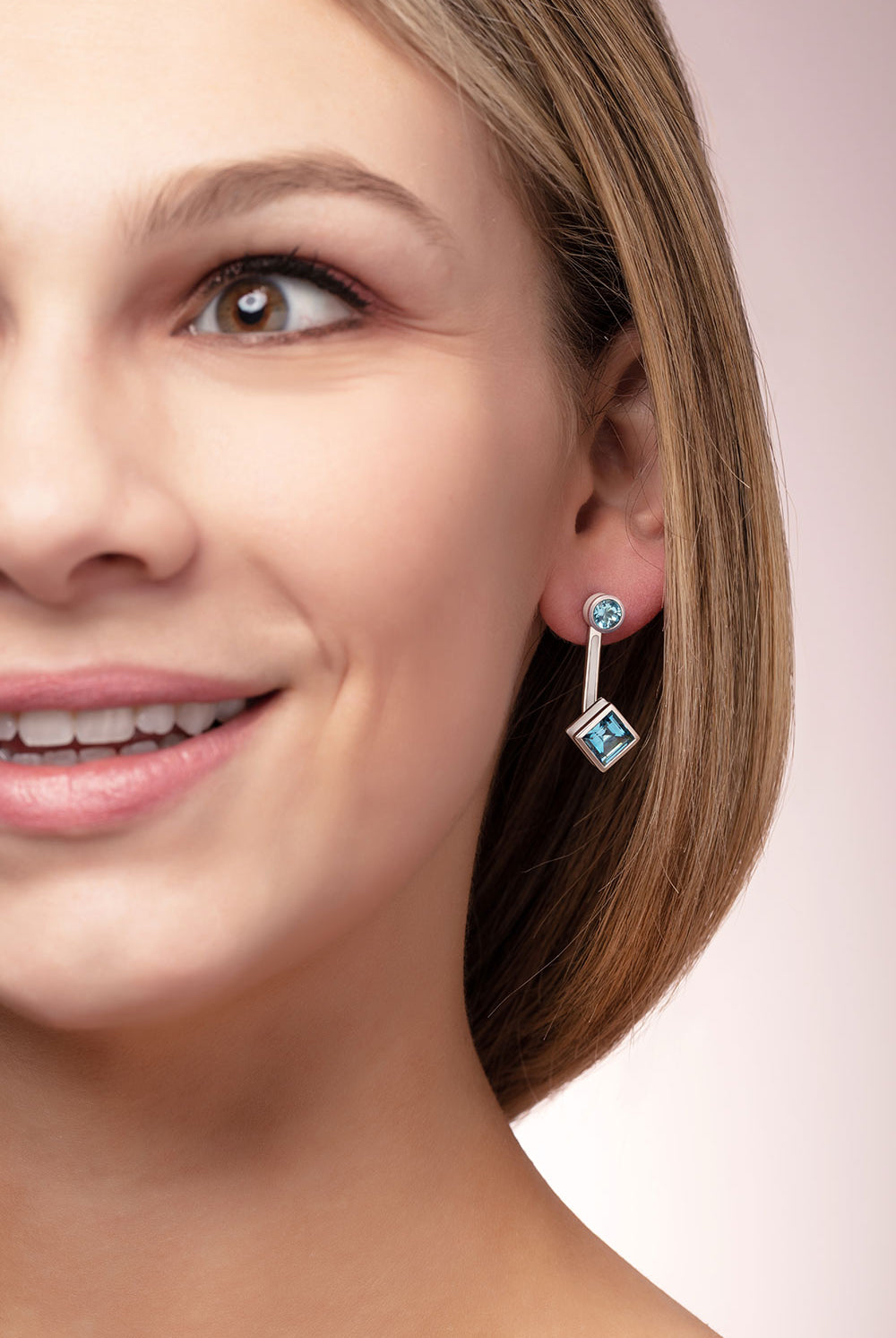 ‘Mix and Match’ earring drops with a pair of square Ostro Blue Topaz set in sterling silver paired with our ‘Play by ear’ stud earrings with a pair of round Ostro Blue topaz set in Sterling Silver being worn by model