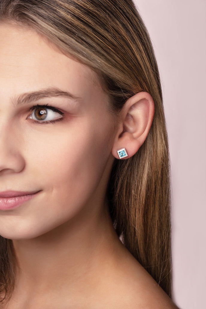 ‘Play by ear’ stud earrings with a pair of square Ostro Blue topaz set in Sterling Silver being worn by model